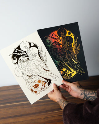 A person holding two foil art prints in black and white.