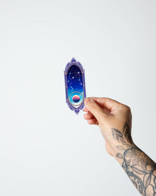 a tattooed hand holding Libra zodiac sign constellation holographic sticker with ruling planet of Venus.