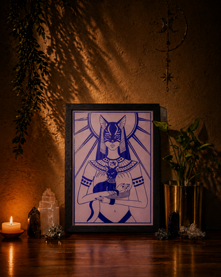 Framed artwork of a stylized figure with cat-like features on a wooden surface with candles and plants.