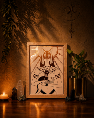 Framed artwork of Bestat on a wooden surface with candles and crystals in a warm, dimly lit room.