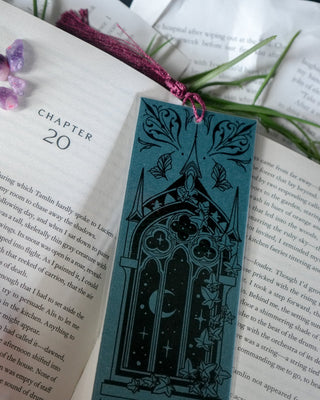 Open book with decorative bookmark and purple gemstones on a book background