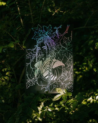 Iridescent silver foil of a woman's face and floral elements on a dark background