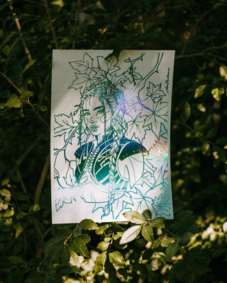 Warrior print of a woman with leaves on a mint background, surrounded by green foliage.