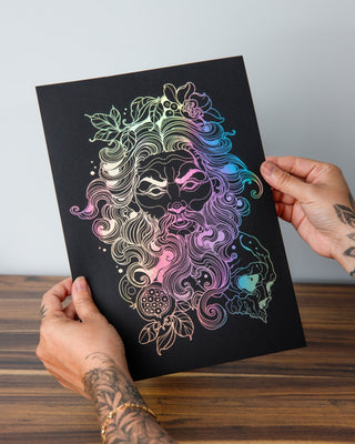 A person holding a black and gold art print of Hades, the ruler of the Underworld, with intricate patterns and designs.