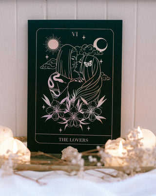 Decorative poster titled 'The Lovers' with candles and crystals on a table.