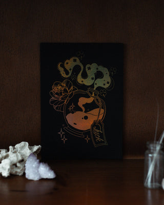 Decorative mini print with luck potion bottle design on a dark background, placed on a wooden surface.