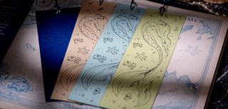 Set of colourful mermaid bookmarks on an open book.