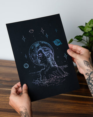 Moonlight Dip art print in holographic silver foil on black card, a woman gliding through water beneath the stars
