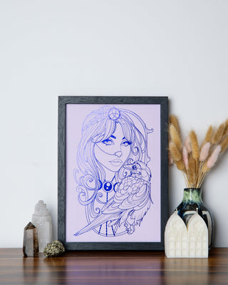 A framed The Morrigan art print in indigo foil on purple card with a raven, styled on a wooden shelf with crystals