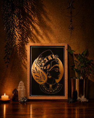 Decorative framed artwork of Nefertiti on a wooden surface with candles and plants in a warm setting
