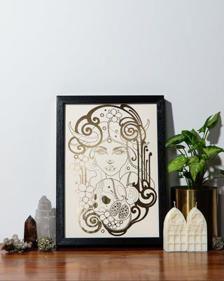 A print of Persephone, the Greek goddess of death and spring, with a black background and gold foil details.