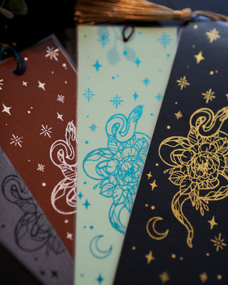 Set of bookmarks snake, a rose and moon, designs on a dark background.
