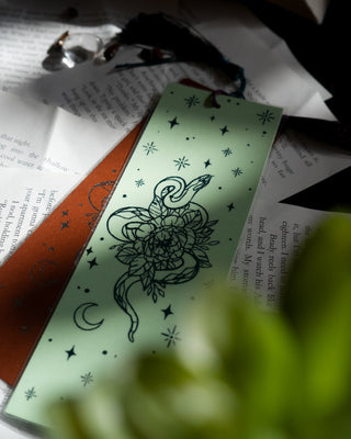 Decorative green bookmark with green design on books.