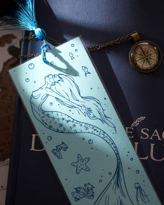 Mermaid-themed bookmark on a book with a map in the background