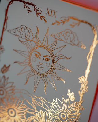 Decorative card with gold sun design in a dark background