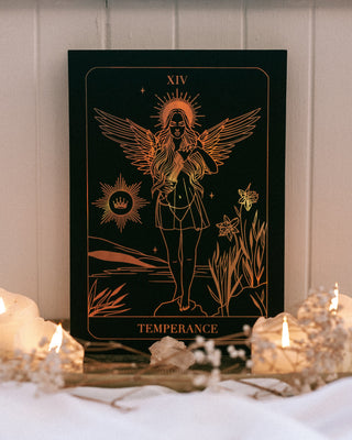 Tarot card titled 'Temperance' with candles and decorative elements on a white surface.