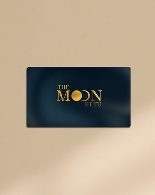 A gift card with gold text The Moon Et Tu with a beautiful navy blue background.