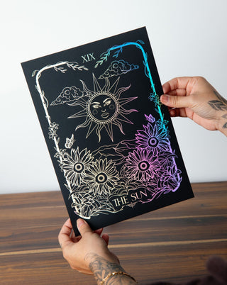 A framed print titled 'The Sun' with solar motifs and a sun-kissed shimmer.