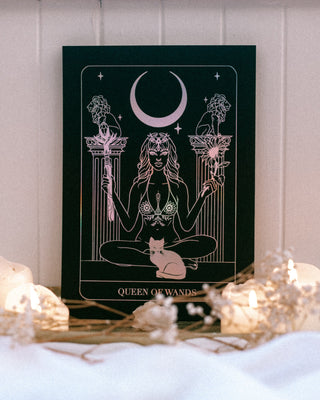 Decorative poster with a woman and moon design on a bed with candles and lights.