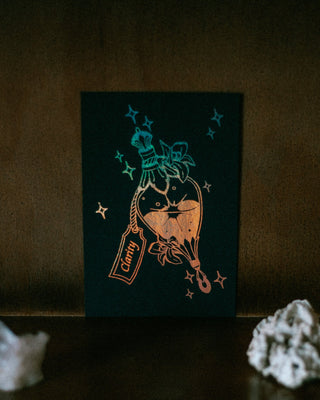 A mini print featuring a stylized illustration of a potion bottle with a label reading 'Clarity' and star accents, displayed against a dark brown textured background.